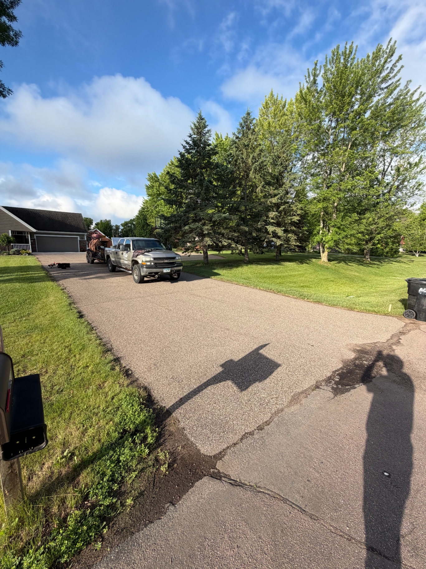 Residential driveway before service with contractor truck parked near the garage