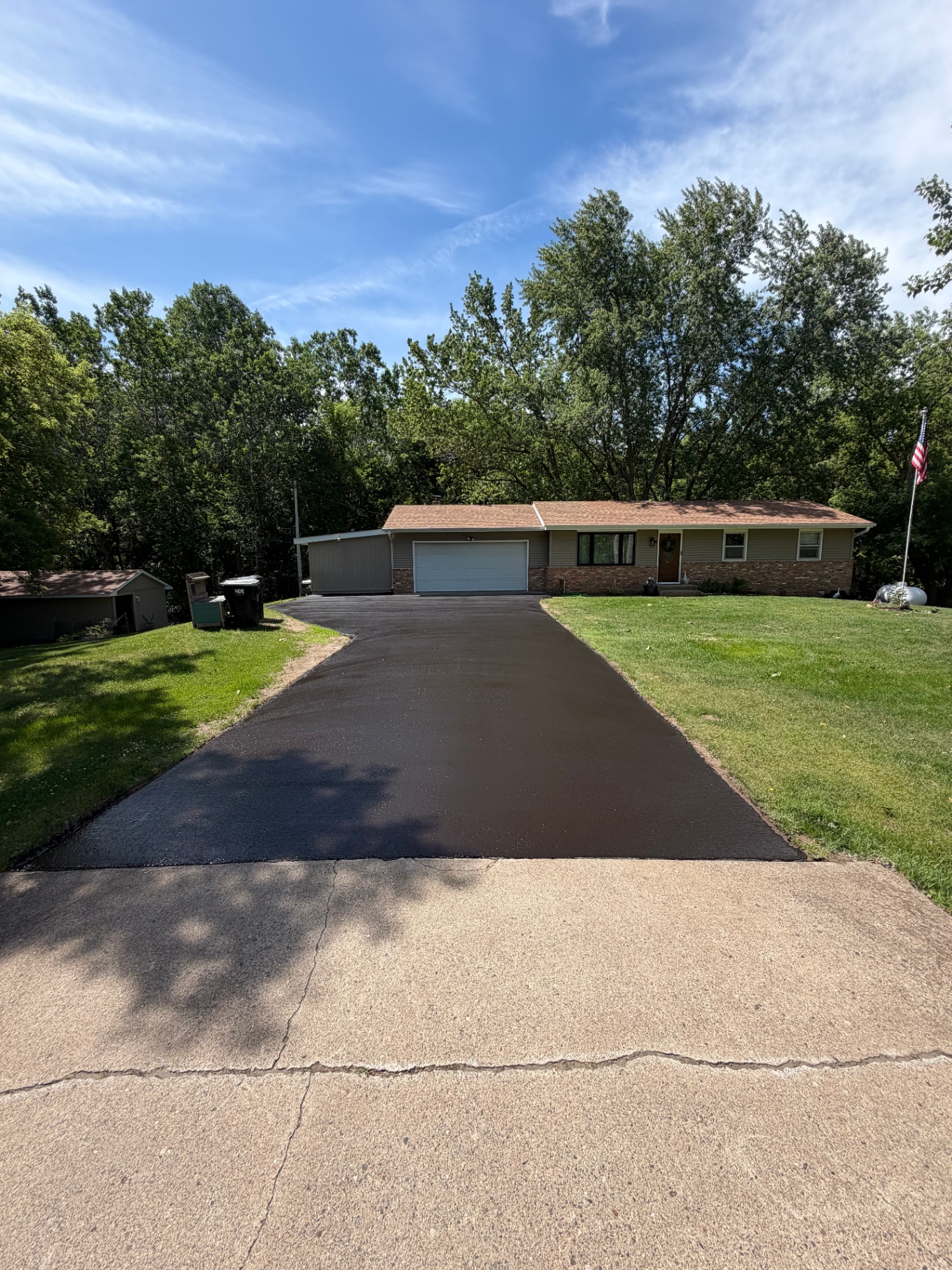 Completed residential driveway seal coat with a clean dark finish