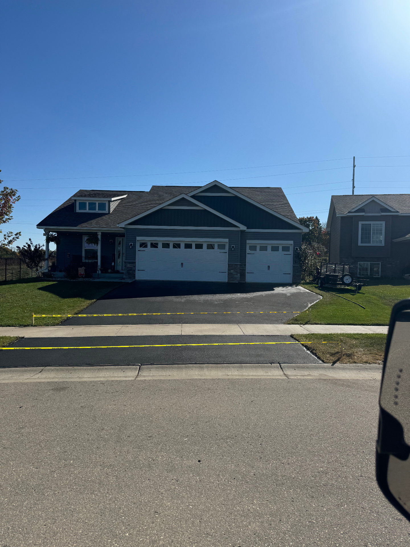 Freshly finished residential driveway photographed from the street after sealing